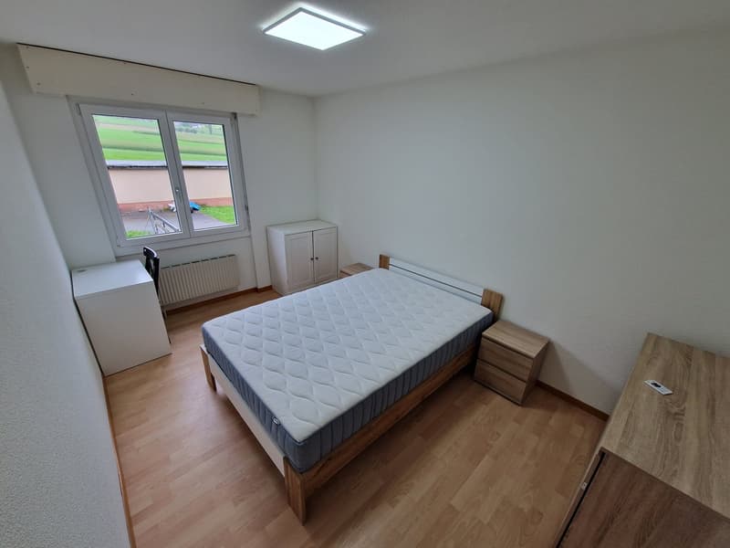 single bed, wooden floor, two nightstands, a wardrobe, a window, heating radiator