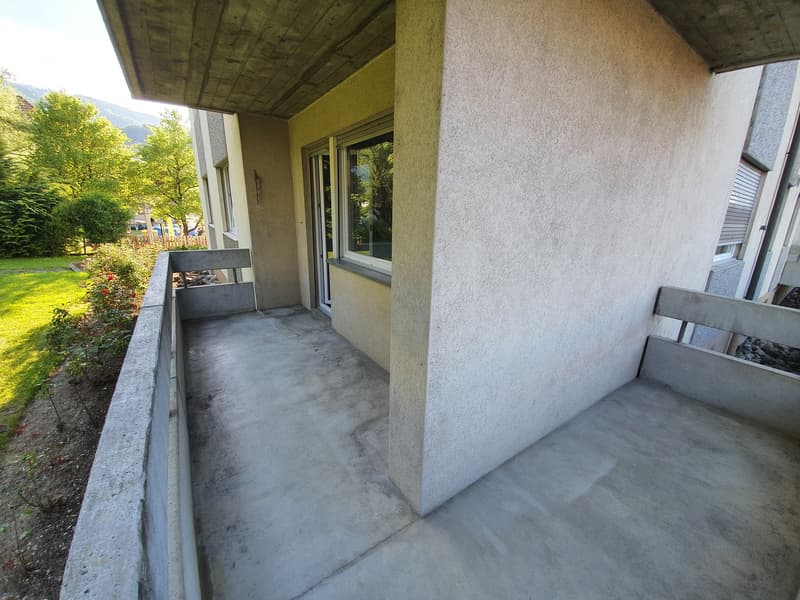 Concrete balcony with a large wall and railings