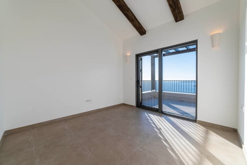 tiled floor, sliding glass doors to balcony, wall lamps, ocean view