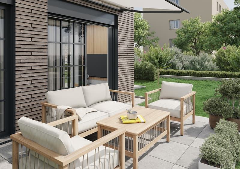 The image shows an outdoor patio area with a modern, minimalist design. The patio features a wooden sofa and armchair set with white cushions, a wooden coffee table, and a sliding glass door leading to the interior. The patio is surrounded by lush greener
