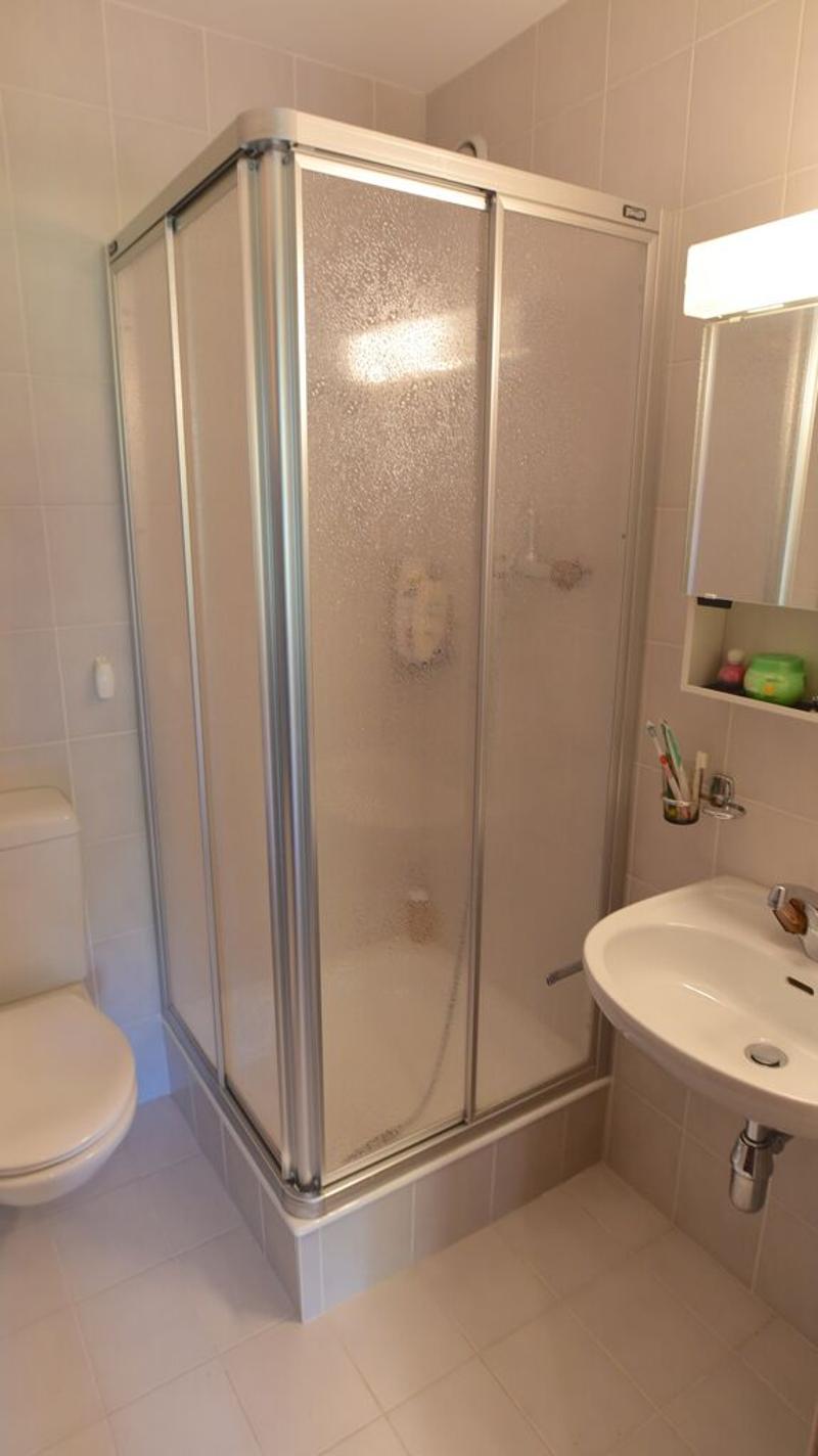 Bathroom with a shower enclosure, toilet, and a sink with a vanity. The shower enclosure has sliding glass doors.