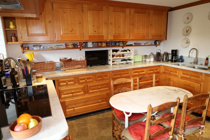 wooden cabinets, white marble countertop, white kitchen table, dining chairs, induction cooker, large sink, faucets, baskets, storage, TV