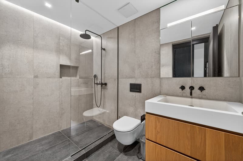 modern style bathroom with white fixtures and concrete walls