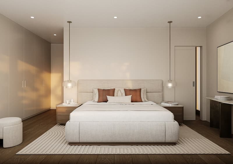A modern, minimalistic bedroom with hardwood floors, a beige bed headboard, two nightstands, a beige rug, pendant lamps, and built-in wardrobes. There are books and a candle on one nightstand and a stool next to the bed.