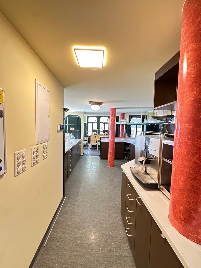hallway, yellow walls, tiled floor, ceiling lamps, shelves, cabinet, coffee machine