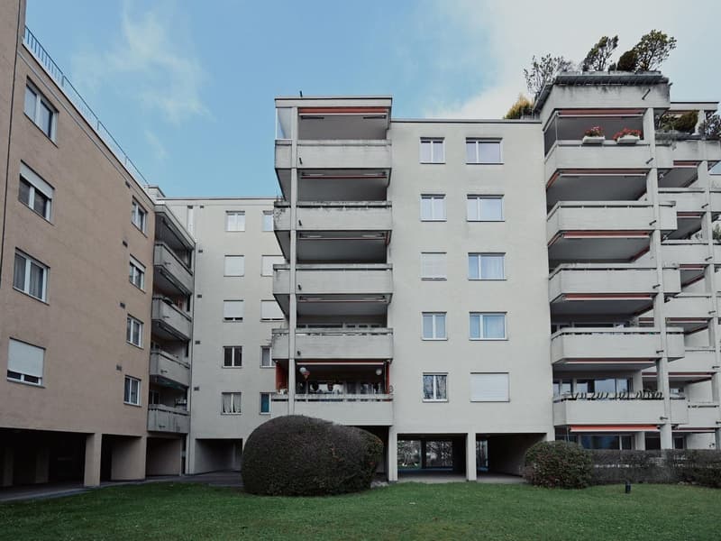 A multi-story building with balconies and a large courtyard in the center