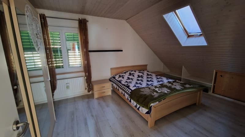 a bedroom with a wooden bed, two nightstands, and a skylight