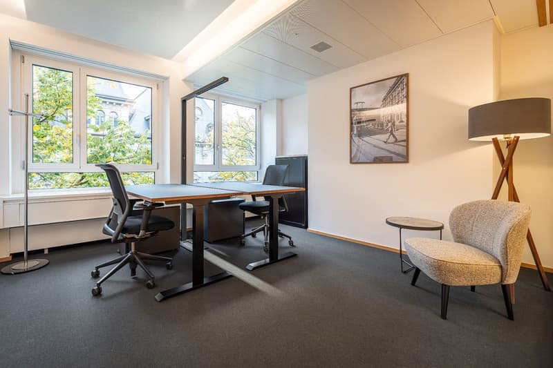 Office room with two desks, chairs, table, lamp, and window.