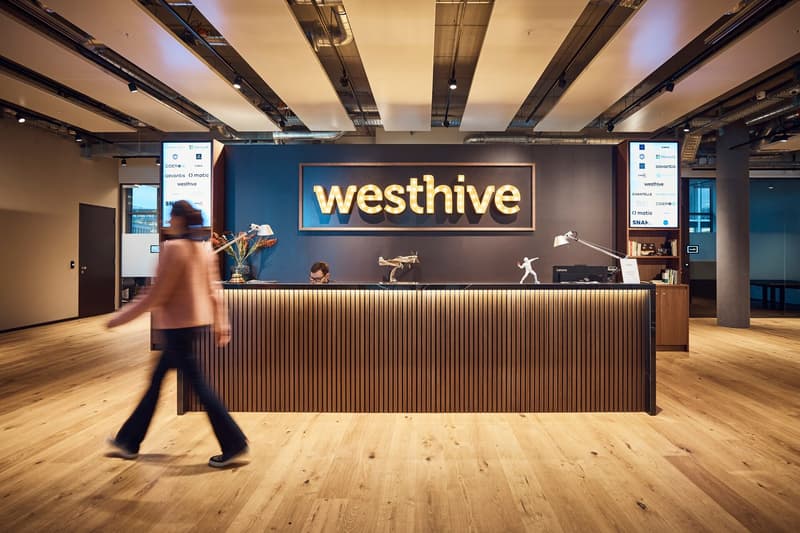 Office reception area, wooden floors, blue walls, large sign with the word Westhive