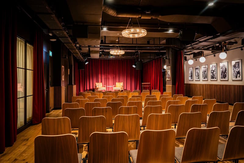 auditorium, wooden chairs, red curtains, chandeliers, wooden wall panels, picture frames