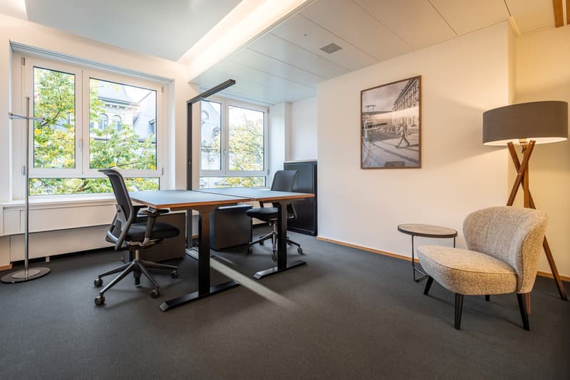 Office room with two desks, office chairs, small chair, standing lamp, picture frame, window