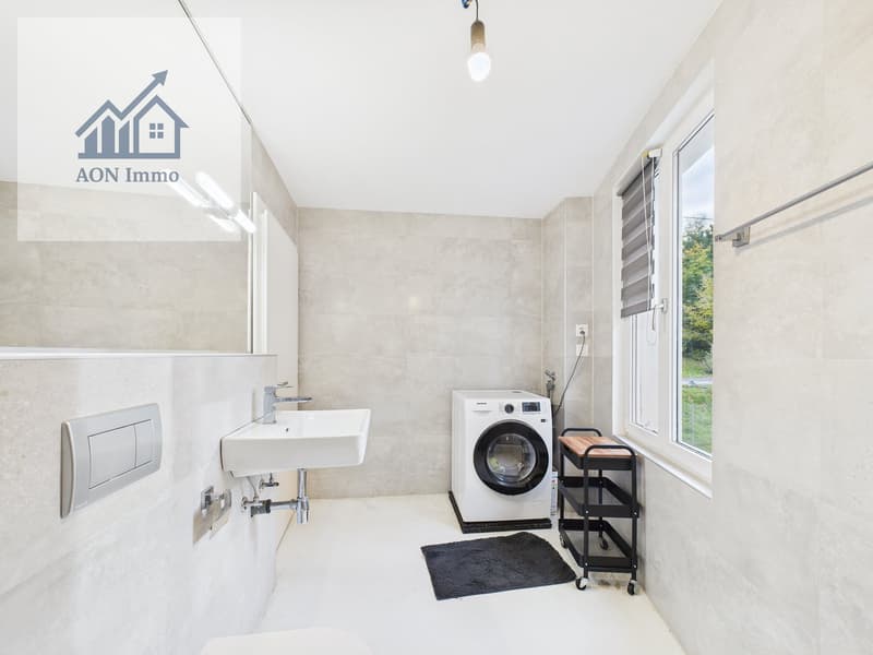 modern bathroom with white sink, white washing machine, white tiles, window, black rug, black shelf