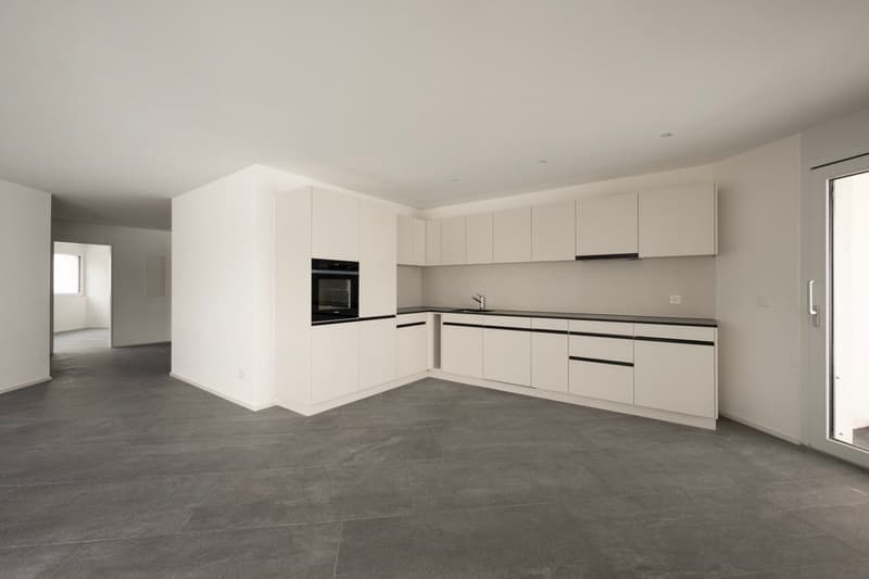 empty kitchen with gray tiles and white cabinets and an oven, dishwasher and sink are present
