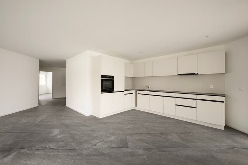 empty room, white cabinets, black countertops, oven, sink