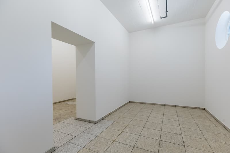 Empty room with white walls, a tiled floor, and a recessed doorway.