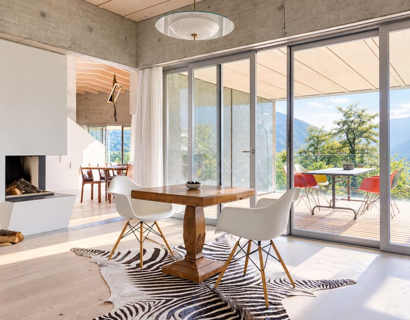 Markante Architektur vor eindrucksvoller Bergkulisse | Architettura distintiva con panorama montano 05 Mueller_Hallauer_0101 Wohn- und Essbereich mit Terrassenzugang | Zona giorno e pranzo con accesso alla terrazza