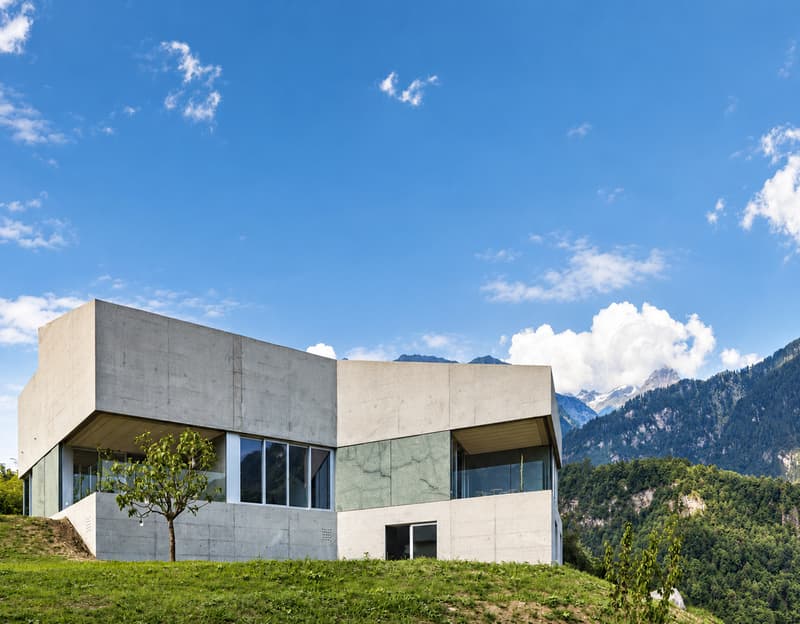 Markante Architektur vor eindrucksvoller Bergkulisse | Architettura distintiva con panorama montano