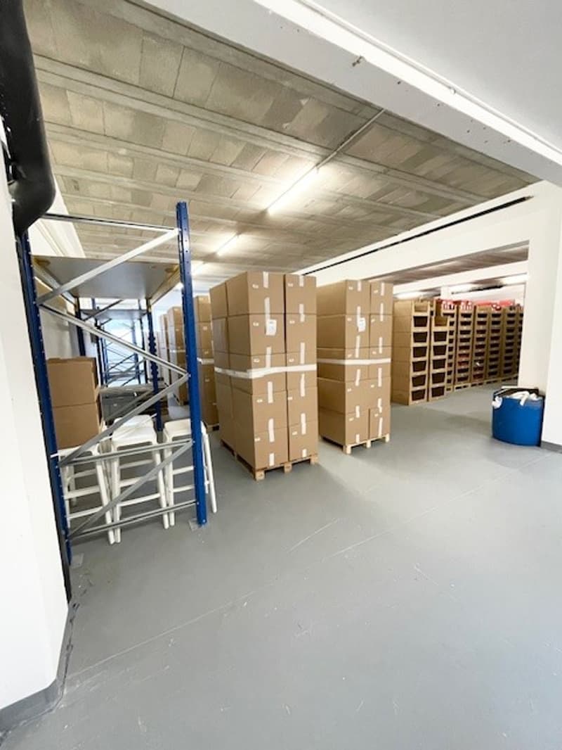 Empty warehouse with storage shelves, boxes, and a blue bucket