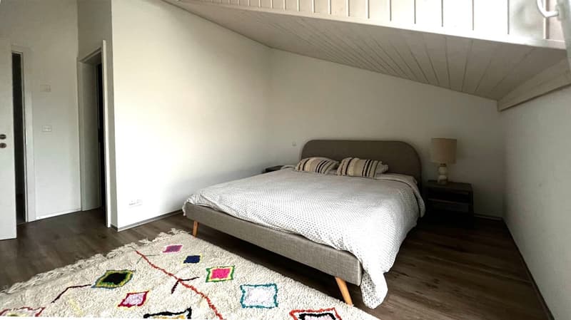 wooden floor, white walls, queen-size bed, nightstands, lamp, rug