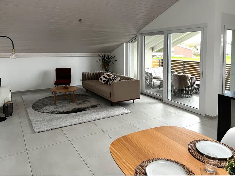 modern living room, gray carpet, beige sofa, wooden table, glass doors to balcony, wooden flooring