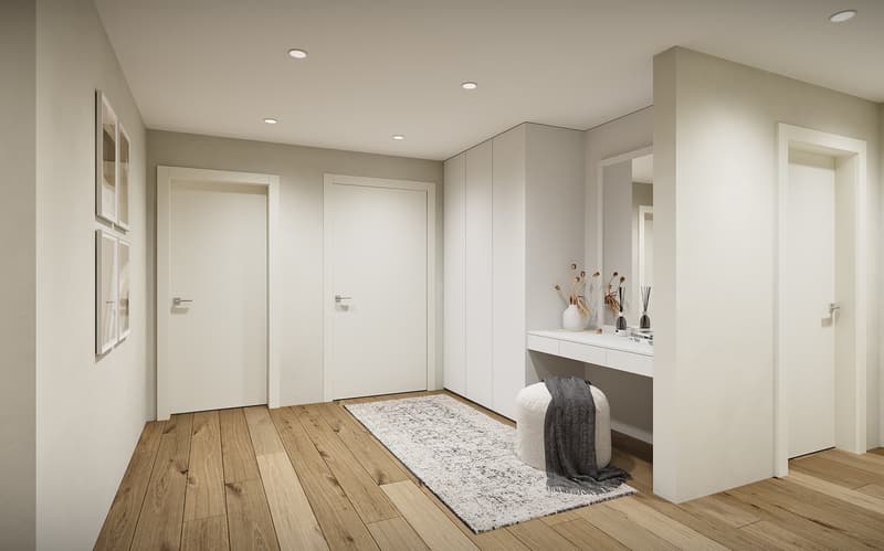 Modern hallway with white walls, wooden floor, white doors, white built-in cabinets, white desk with mirror, white rug, white ottoman, and gray blanket.