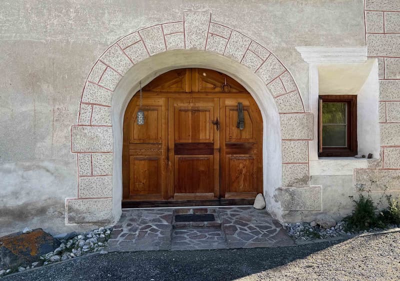 old building, arch doorway, wooden door, stone wall, small window