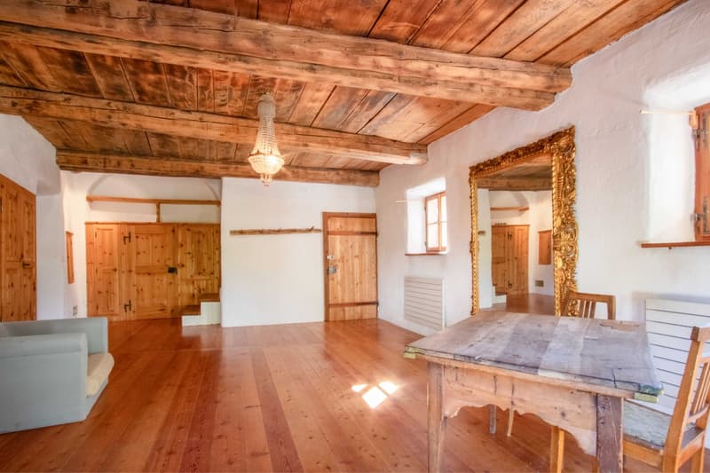 large wooden floor, wooden ceiling, wooden couch, wooden table, chandelier, ornate mirror