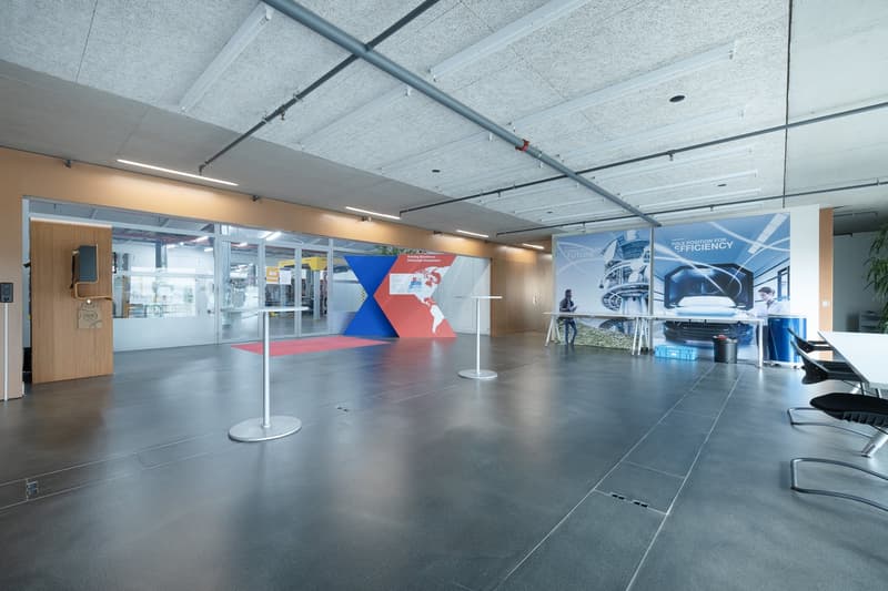large open room, white ceilings, gray floor, banners, tables, chairs
