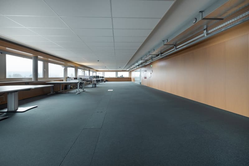 open space, carpet flooring, large windows, modern furniture, office equipment