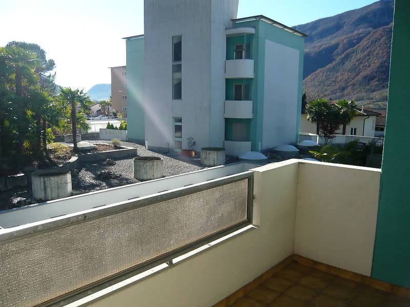 Balcony with tiled floor, metal railing, view of the building and mountain