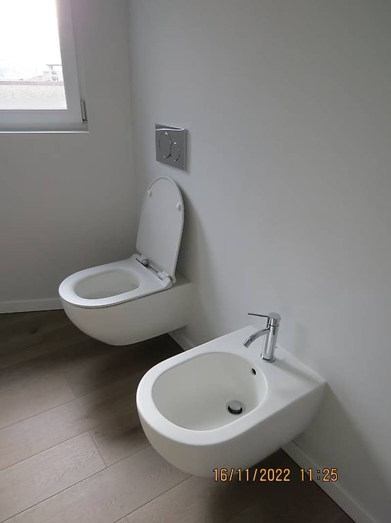 white walls, white sink, white toilet bowl, faucet, small window