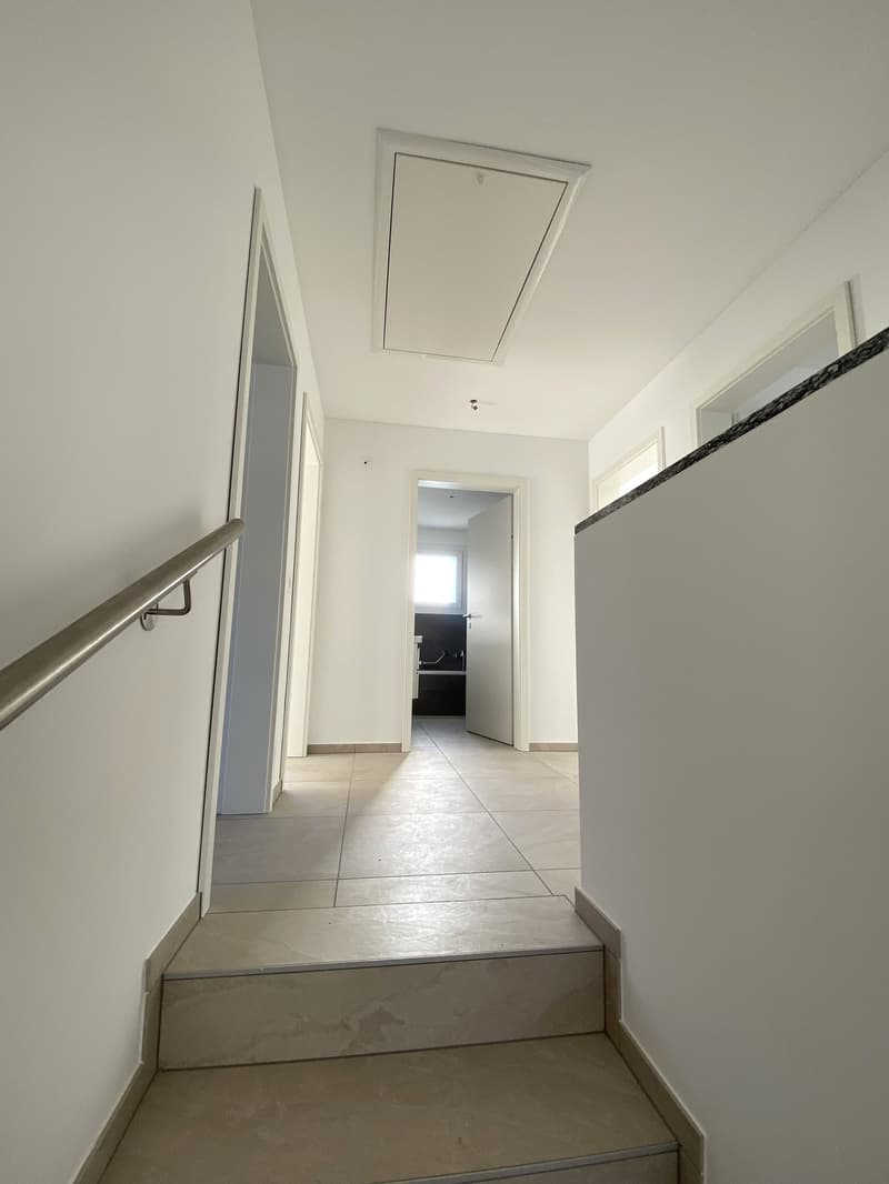 tiled floor, white walls, tiled stairs, railings, door on the left, open door at the end