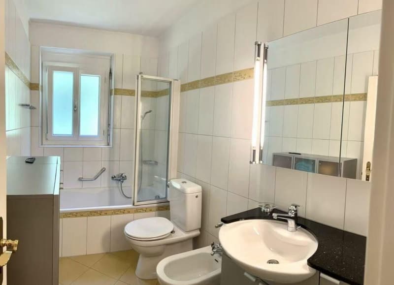white tiles, bathtub, walk-in shower, toilet, bidet, sink, mirror, tile flooring