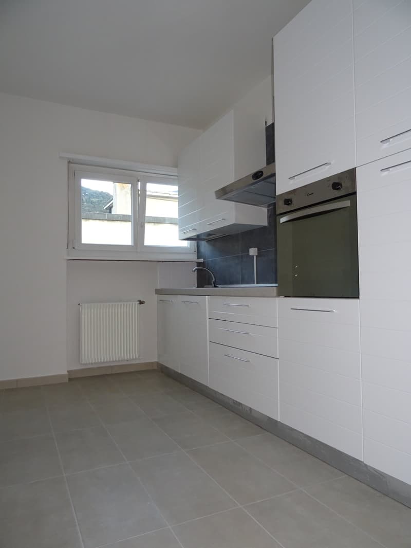 kitchen with white cupboards, tiled floor, window, sink, oven, built-in hood