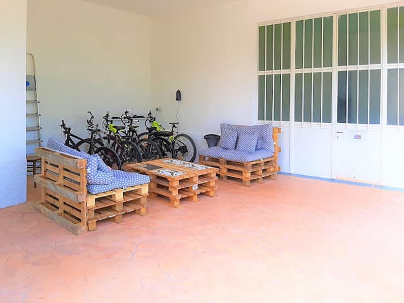 Wooden pallet couches with cushions, wooden tables, bicycles, ladder