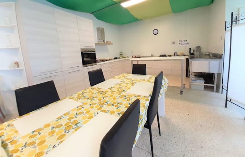 Modern kitchen, white cabinetry, tiled floor, modern appliances, central island, dining table, black chairs