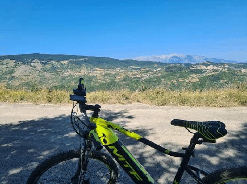 yellow and black e-bike on a path with mountains in the background