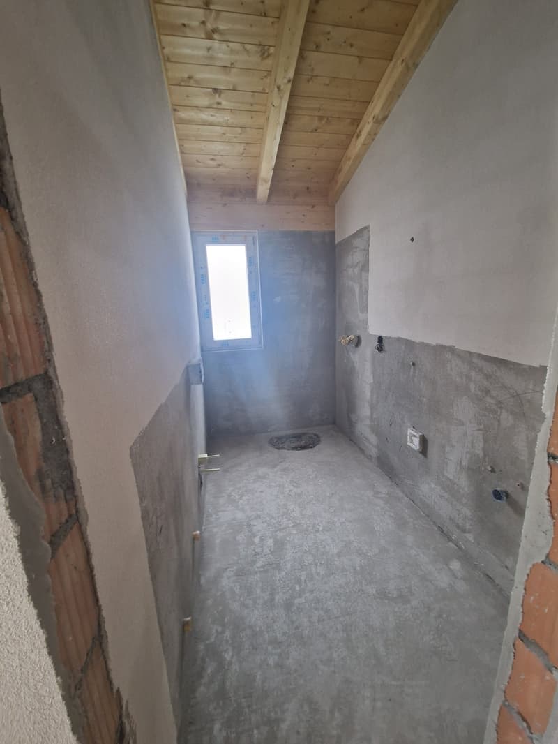 unfinished room, concrete floor, wooden ceiling, small window