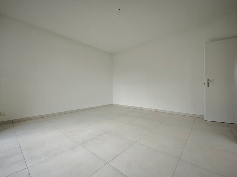 Empty room, white walls, white floor tiles, power outlet on the wall