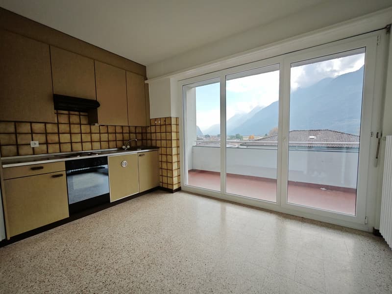 empty kitchen with tiles, wooden cabinets, a balcony with view to mountains