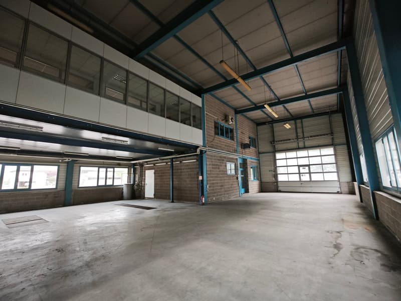 large open space, metal beams, glass windows, brick walls, fire extinguisher, doors