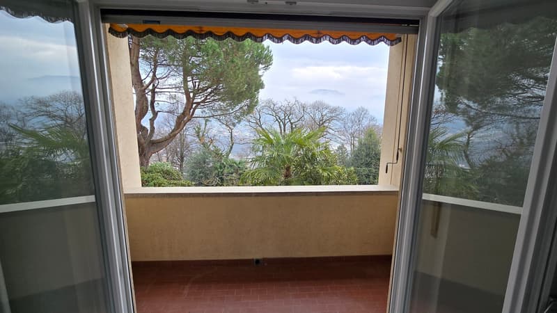 tiled floor, open sliding glass doors, balcony, views of trees and mountains