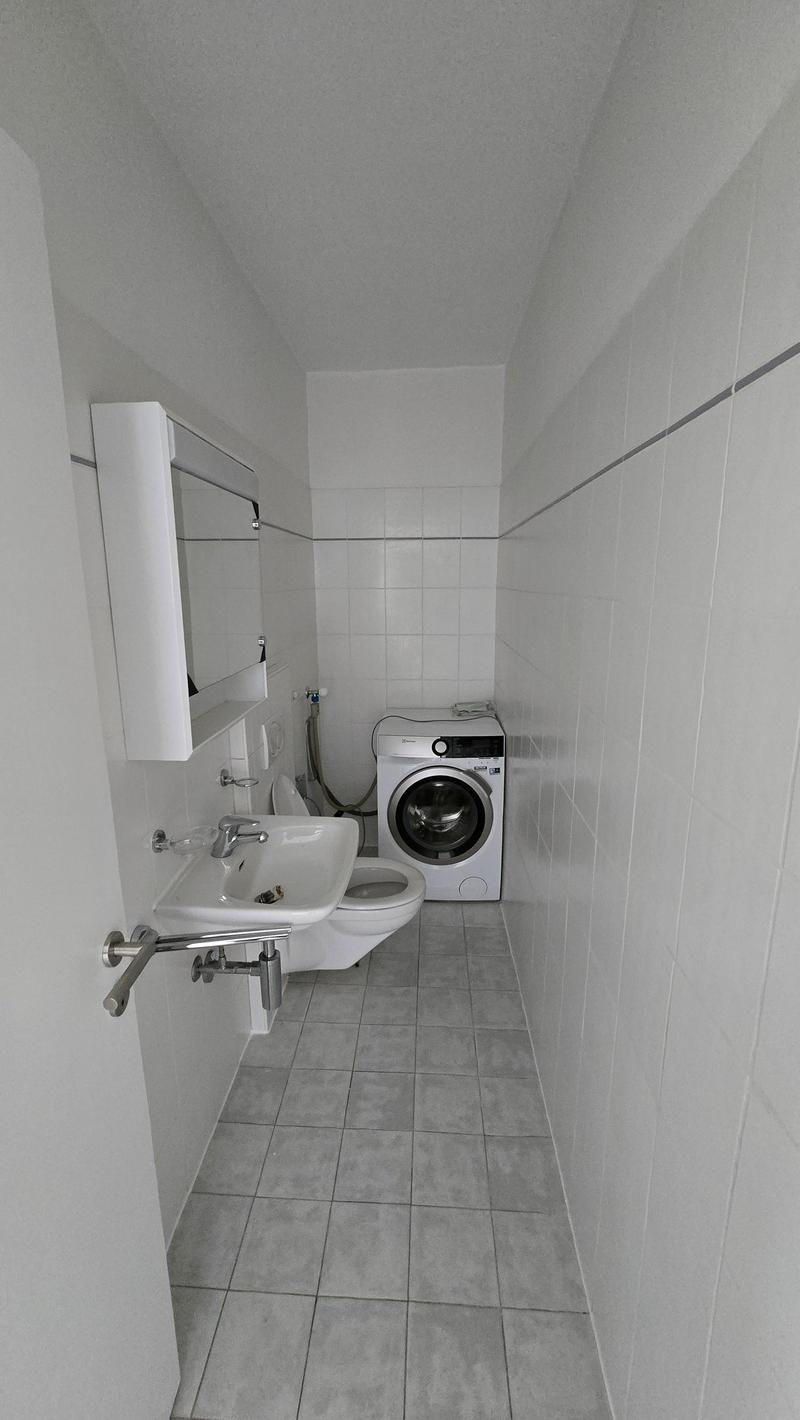 Modern compact bathroom, sink, mirror, washing machine, toilet, tiles