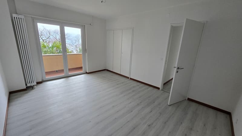 Empty room with sliding glass doors leading to a balcony