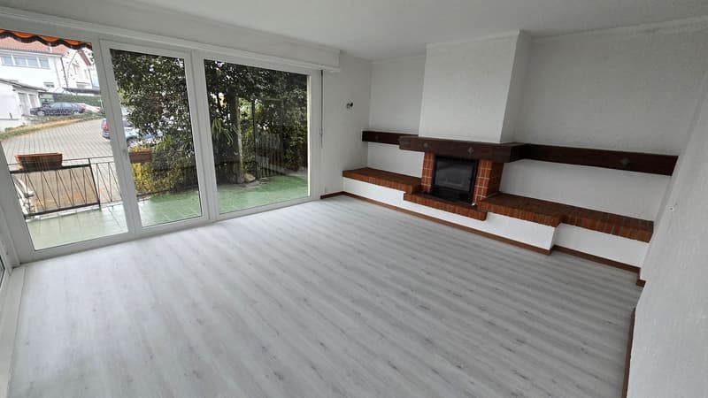 Empty room, fireplace, sliding glass doors, balcony, light flooring