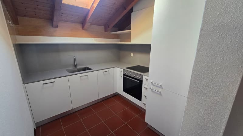 modern kitchen with white cabinets, gray countertops, red tiles, stainless steel sink, oven, and faucet