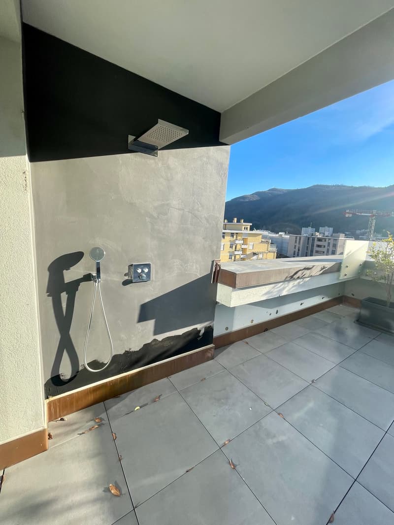 tiled floor, outdoor shower, metal shower head, shadow on wall, view of cityscape