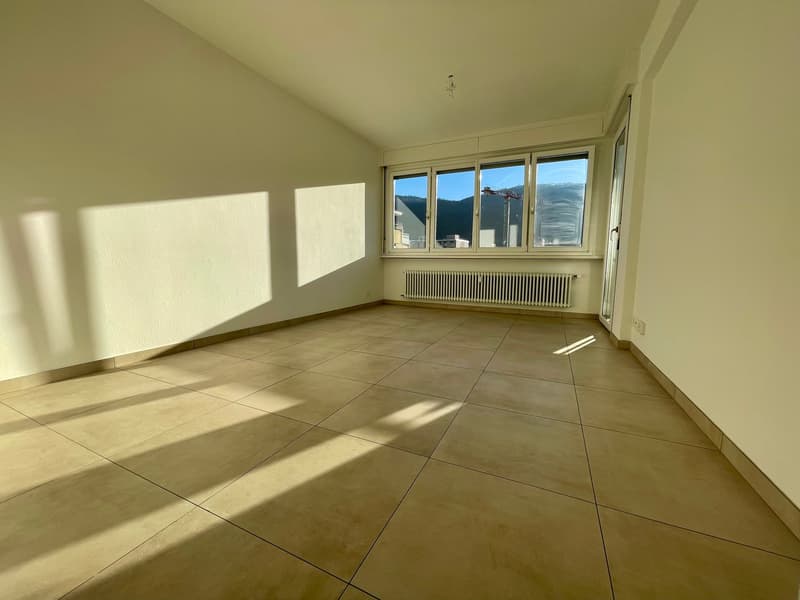 empty room with tiled floor, white walls, window, radiator