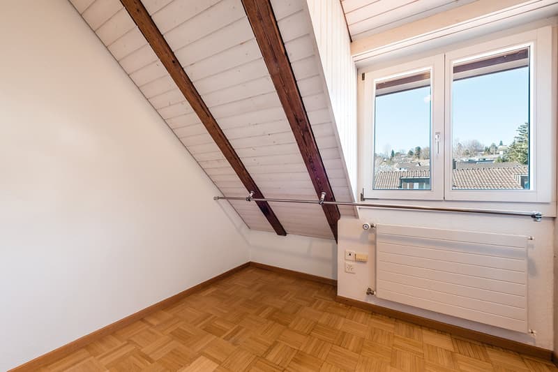 empty room, wooden flooring, slanted ceiling, window, radiator