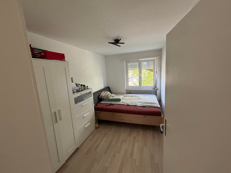 Bedroom with bed, cabinet, and window
